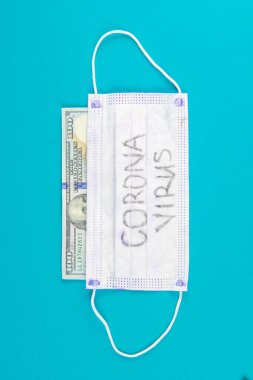 Coronavirus Wuhan. ABD karantinası, 100 dolarlık banknot ve üzerinde koronavirüs yazan tıbbi maske. Salgın ve Coronavrius 'a karşı koruma kavramı..