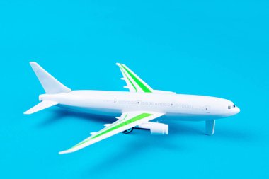 Mavi arka planda beyaz uçak, üst görünüm.