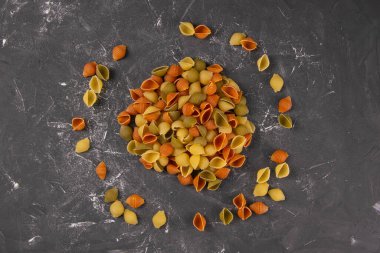 Pasta Conchiglie Rigate, rengarenk pişmemiş kabukların karışımı daire şeklinde. Dokulu İtalyan yemekleri konsepti. Üst görünüm düzlüğü yakın yatar.