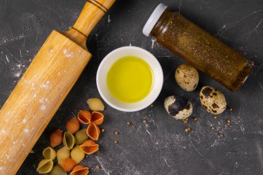 Pasta Conchiglie Rigate, rengarenk pişmemiş kabukları hamur, zeytinyağı, baharat ve bıldırcın yumurtası karışımı. Dokulu İtalyan yemekleri konsepti. Üst görünüm düzlüğü yakın yatar, boşluk temizler.