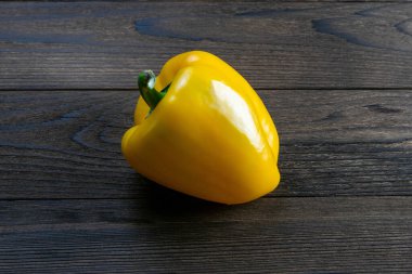 Tek olgun organik tatlı sarı biber. Koyu ahşap masada. Kalp için sağlıklı yiyecek seçimi, yaşam konsepti, kopyalama alanı.