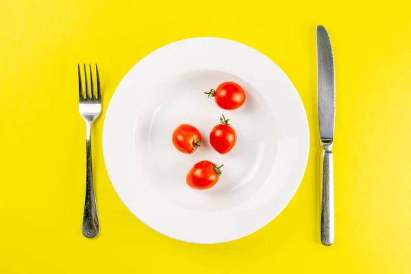 Ντομάτες Λευκό Πιάτο Μαχαίρι Και Πιρούνι Φόντο Κρεμμυδιού Δημιουργική Ιδέα — Φωτογραφία Αρχείου