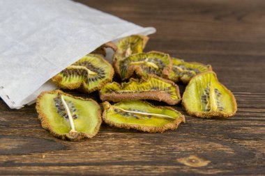Kurumuş Kivi 'nin resmi, kese kağıdından siyah ahşap bir tahta dokuya düşmüş..