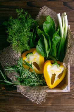 Ahşap arka planda taze sebze. Lahana, biber, yeşil soğan, avokado, dereotu ve maydanoz. Üst görünüm, yakın plan.