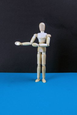 Siyah masa ve mavi arka planda tahta manken. Doğru konsept. Yakın plan.