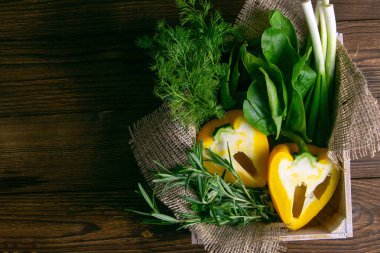 Ahşap arka planda taze sebze. Lahana, biber, yeşil soğan, avokado, dereotu ve maydanoz. Açık alanlı en üstteki görünüm.