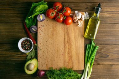 Temiz uzayı olan tahta tahta bir tahta. Domates ve dereotu, zeytinyağı, baharat, biber, avokado, yeşil soğan, belkemiği ve sarımsak. Üst Görünüm.