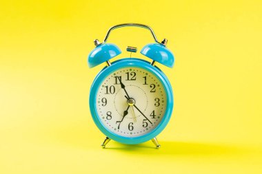 Sarı arka planda mavi alarm saati. Ön görünüm.