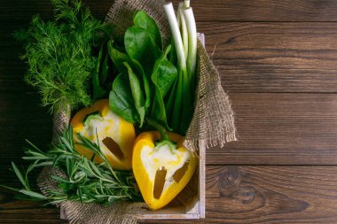 Ahşap arka planda taze sebze. Lahana, biber, yeşil soğan, avokado, dereotu ve maydanoz. Açık alanlı en üstteki görünüm.