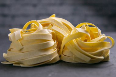 Siyaha izole edilmiş sütun çiğ yuva makarnası. Ön görünüm