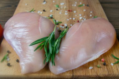 Tahta tahtada pişirmek için taze çiğ tavuk fileto ve sebze. Üst görünüm, yakın plan.