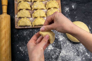 Tahtaya un konmuş hamur köfteleri, pişirmeden önce ellere Varenik heykeli yapılır. Üst görünüm, yakın plan.