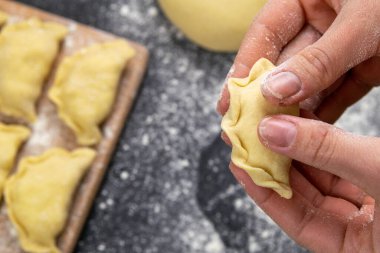 Tahtaya un konmuş hamur köfteleri, pişirmeden önce ellere Varenik heykeli yapılır. Üst görünüm, yakın plan.
