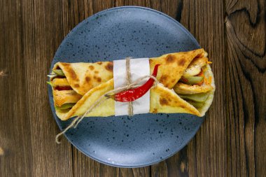 Gri, lezzetli kebap rulolarını ahşap masaya koyar..