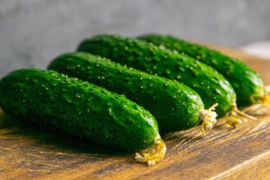 Ahşap bir masada salatalık, eski tahtaların arka planında. Yakın plan..