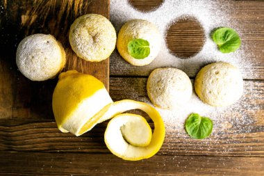 Koyu ahşap bir masanın üzerinde limonlu ve naneli kekler. Üst görünüm, yakın plan.
