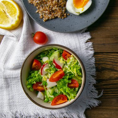 Karabuğday lapası, salatalık domates salatası ve haşlanmış yumurta ile pozitif yaşam. Doğal ürünlerden lezzetli ve sağlıklı yiyecekler. Kapat.