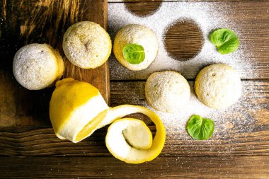 Koyu ahşap bir masanın üzerinde limonlu ve naneli kekler. Üst görünüm, yakın plan.
