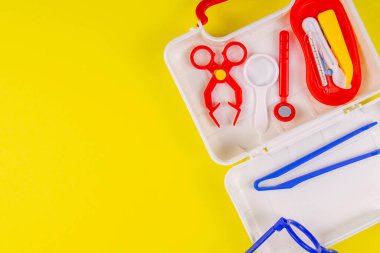 Oyuncak- Sarı masaya ilk yardım çantası. Bir çift küçük doktor. Açık alanlı en üstteki görünüm.
