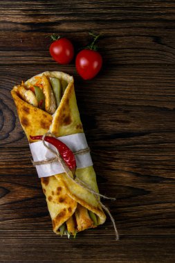 İki döner kebap, et, sebze ve patates kızartması. Pita ekmeği, ahşap bir masada yakın plan..