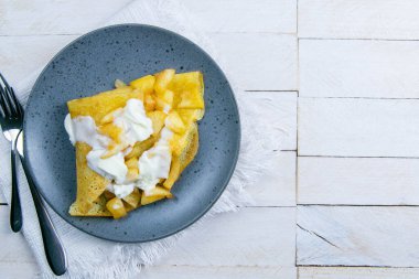 Elmalı tarçınlı krep ve dondurma. Açık alanlı en üstteki görünüm.