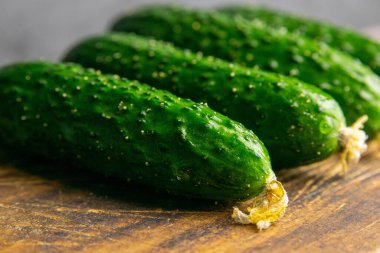 Ahşap bir masada salatalık, eski tahtaların arka planında. Yakın plan..