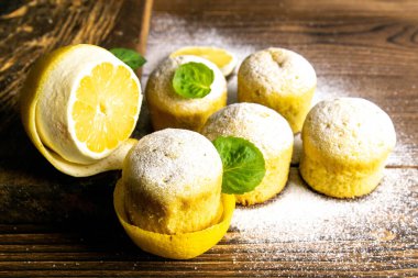 Koyu ahşap bir masanın üzerinde limonlu ve naneli kekler. Üst görünüm, yakın plan.