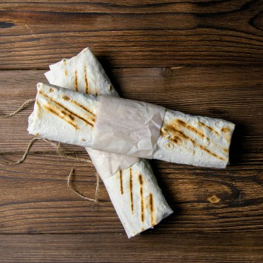 Koyu ahşap bir masanın üstünde iki sarma. Yakın çekim..