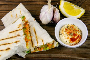 Ev yapımı shawarma, burrito, sebze ve soslu tavuk dürümü. Üst görünüm içeriği.