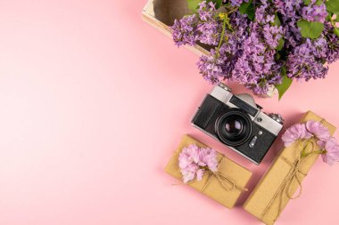 Kamera, hediye ve güzel mor bir leylak. Ay - Mayıs, Haziran ve Temmuz. Açık alanlı en üstteki görünüm.