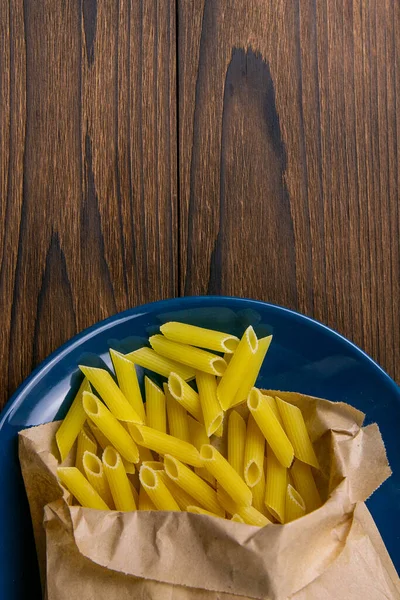 Pene Lisce Pasta Una Bolsa Papel Artesanal Plato Azul Sobre — Foto de Stock