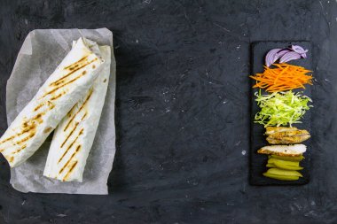 Ev yapımı shawarma, burrito, sebze ve soslu tavuk dürümü. Üst görünüm shawarma ve temiz boşluklu malzemeler.