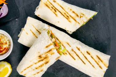 Ev yapımı shawarma, burrito, sebze ve soslu tavuk dürümü. Üst görünüm shawarma ve temiz boşluklu malzemeler.