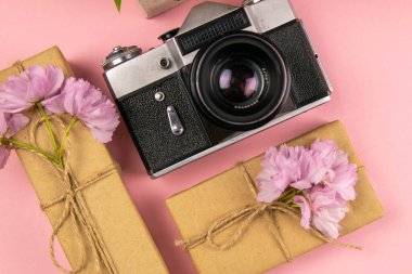 Kamera, hediye ve güzel mor bir leylak. Ay - Mayıs, Haziran ve Temmuz. Üst görünüm, yakın plan.