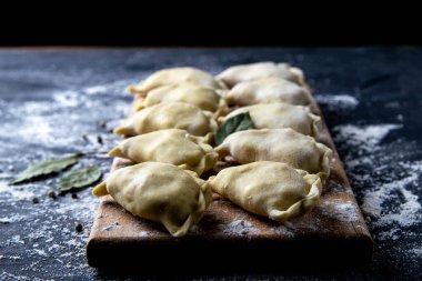 Çiğ köfte ve patates. Koyu arkaplanda tahtadan yapılmış hamur tatlısı. Üst görünüm, yakın plan.