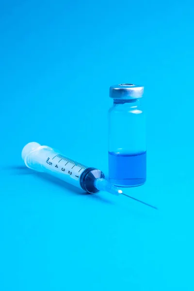 파란색 배경에 코로나 바이러스 의료용 주사기 — 스톡 사진
