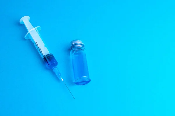 Skleněné Injekční Lahvičky Lékařská Stříkačka Koronavirovou Vakcínou Modrém Pozadí — Stock fotografie