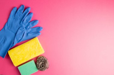 Mutfak, banyo ve diğer odaların farklı yüzeyleri için renkli temizlik seti. Pembe arka planda mesaj ya da logo için boş bir yer. Temizlik hizmeti konsepti. Bahar başı düzenli temizlik. Üst görünüm.