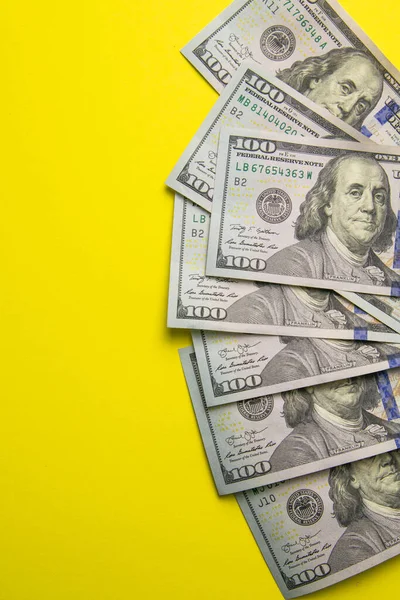 Renkli arka planda 100 dolarlık banknotlar. Metin işi para konseptin için boş bir yer. Sarı arka planda Amerikan doları nakit..