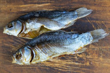 Ahşap zemin üzerinde kurutulmuş tuzlu haç balığı. Atıştırmalık bira..