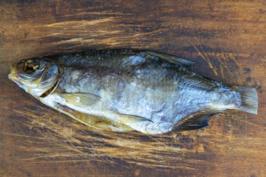 Ahşap arka planda kurutulmuş çipura. Atıştırmalık balıktan biraya. Kapat..
