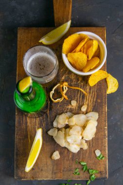 Kurutulmuş ahtapot, bira, limon ve patates cipsi. Balığı birayla atıştır. Yakın plan..