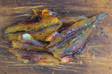 Ahşap arka planda kurutulmuş mavi mezgit balığı. Atıştırmalıktan biraya. Kapat..