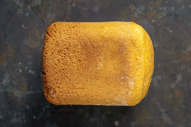 Karanlık arka planda taze kokulu ekmek. Koyu masa arkasında pişmiş ekmek çeşitleri. Masada taze kokulu ekmek. Üst görünüm, yakın plan.