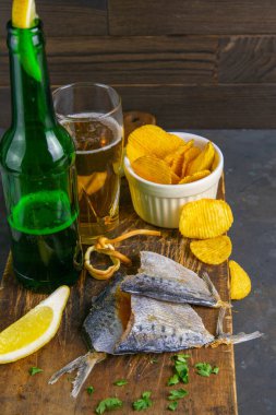 Kelebek şeklinde kırmızı biber, bira, limon ve patates cipsi. Balığı birayla atıştır. Yakın plan..