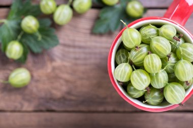 Taze böğürtlenler, ahşap bir masada bir fincanda yakından çekiliyor.. 