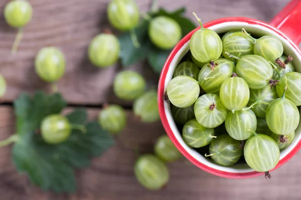 Verse Bessen Kruisbessen Close Een Mok Een Houten Tafel — Stockfoto