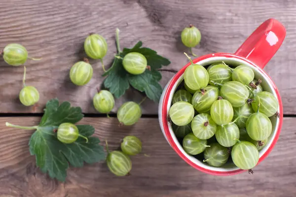 Verse Bessen Kruisbessen Close Een Mok Een Houten Tafel — Stockfoto