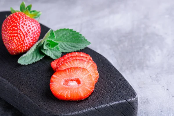 Verse Aardbeien Plakjes Munt Een Snijplank Grijs Beton Achtergrond — Stockfoto