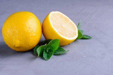 Gri bir arka planda taze limon ve nane.